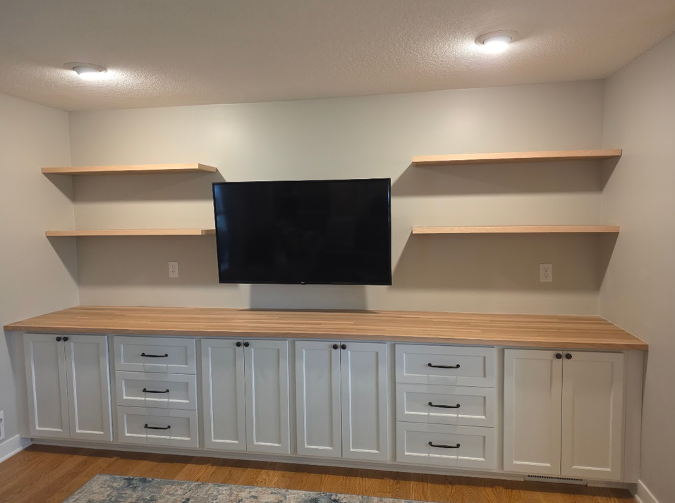 Custom entertainment cabinetry with wood countertop and floating shelves
